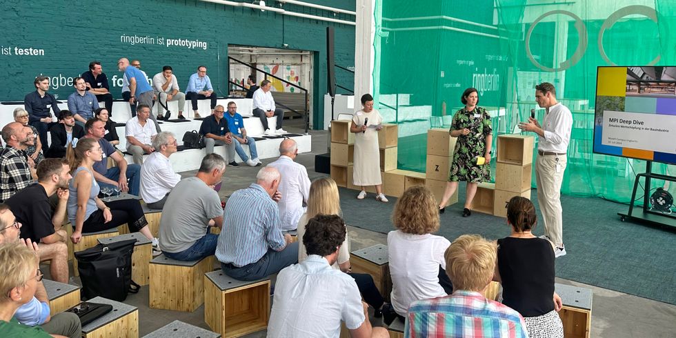 Eine Präsentation von 3 Personen vor einer Gruppe Zuhörern