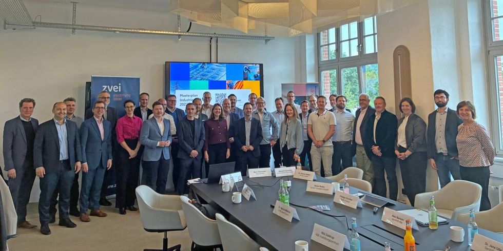 Eine Gruppe von Menschen in einem Konferenzraum zu einem Gruppenbild aufgestelt