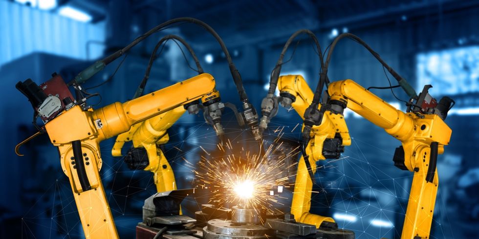 Gelbe Roboterarme führen eine Schweißarbeit aus