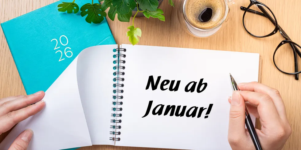 Ein weißer Block mit der Aufschrift "Neu ab Januar!" liegt auf einem Schreibtisch