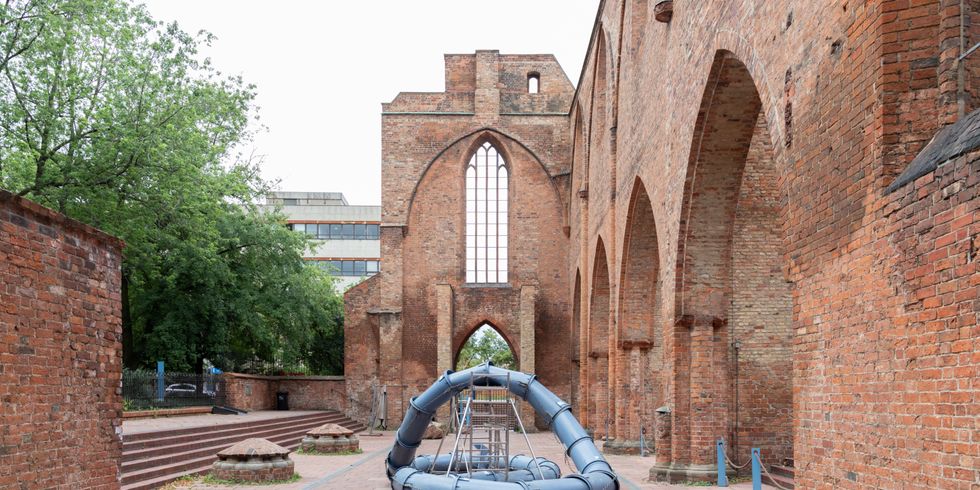 Verschlungene Rohre in einer Kirchenruine
