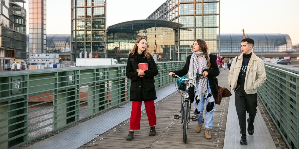 Studenten zusammen über eine Fußgängerbrücke mit dem Fahrrad in Berlin, Deutschland