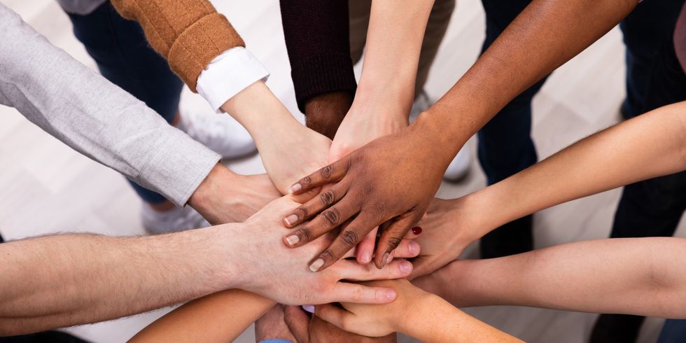 Verschiedene Menschen geben sich einander die Hand