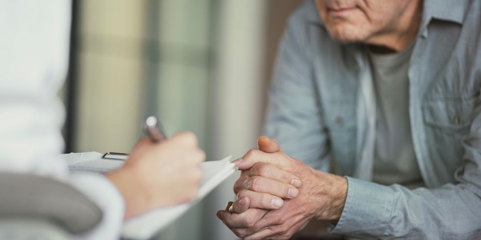 Person spricht mit einem Patienten und macht sich Notizen