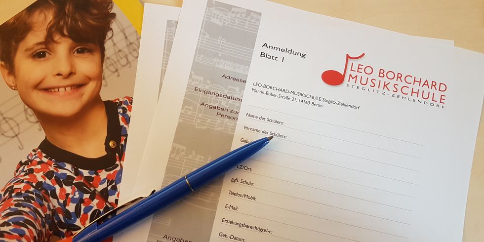 Anmeldebogen mit Stift und Broschüre