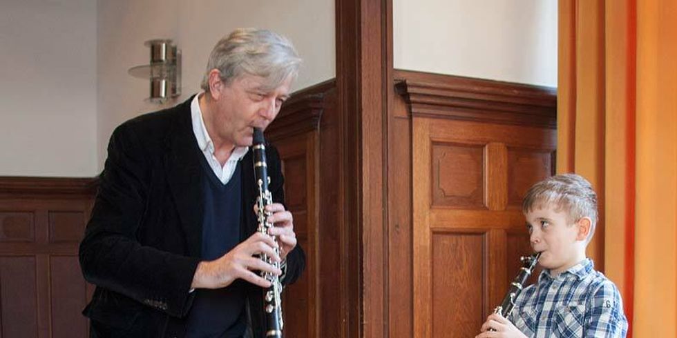 Ein Musiklehrer und ein Junge spielen Klarinette