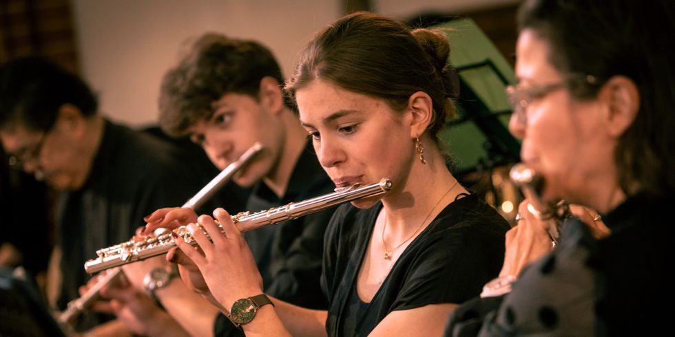 Menschen spielen Querflöte im Orchester