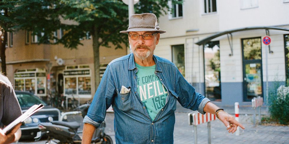 Bewohner in Neukölln zeigt engagiert auf die Straße. Porträtaufnahme im Kiez, Symbol für gelebte Nachbarschaft und Zero-Waste-Engagement in Berlin-Neukölln.