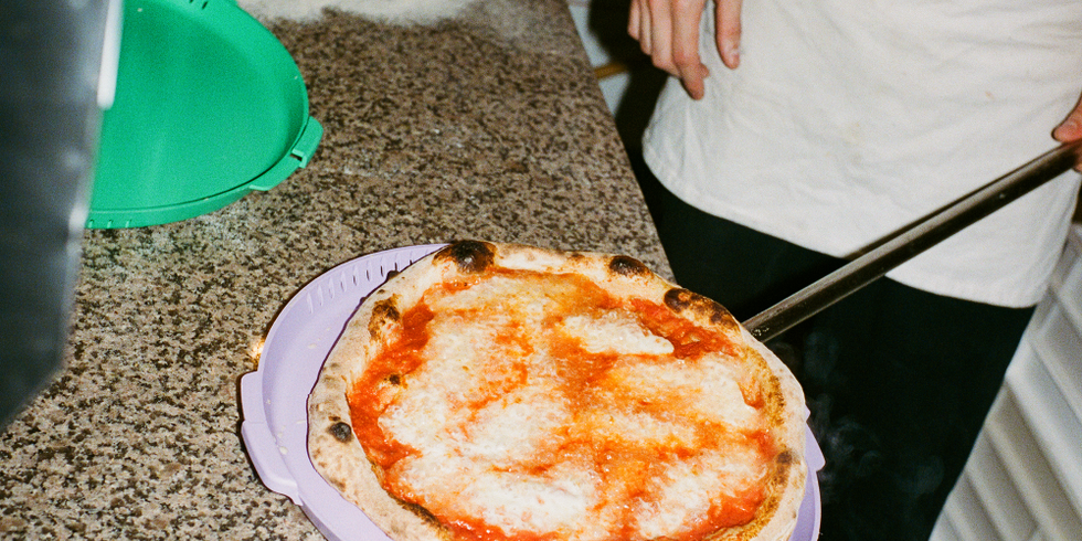 Eine frisch gebackene Pizza wird in einer Mehrweg-Verpackung serviert. Das Bild zeigt, wie Mehrweg-Konzepte in der Gastronomie umsetzbar sind und Abfall reduzieren.