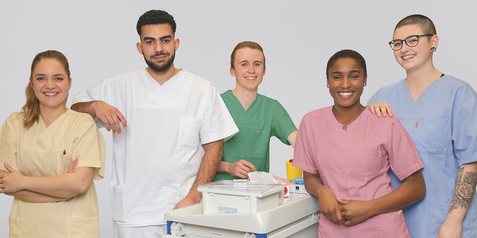 Gruppe von jungen Menschen,, zwei Männer und drei Frauen, gruppiert um einen medizinischen Servicewagen