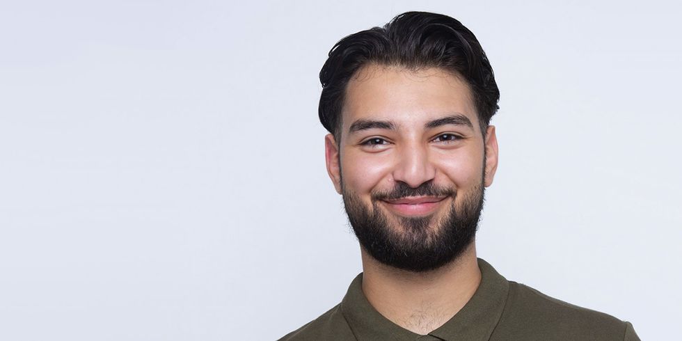 Junger Mann mit schwarzen Haaren und schwarzem Vollbart