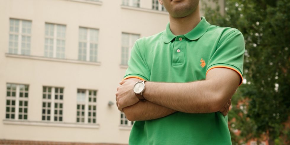 Jugendlicher steht mit verschrämkten Armen vor seiner Schule, Schriftzug: "Fairplay: Schule gerechter machen - #changeTheGame"