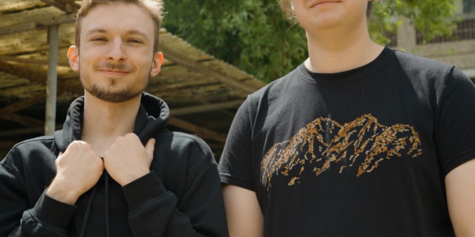 Zwei Jugendliche vor dem Fahrradständer ihrer Schule, Schritzug: "Quest: Keine Klausuern vor 8 - #ChangeTheGame"