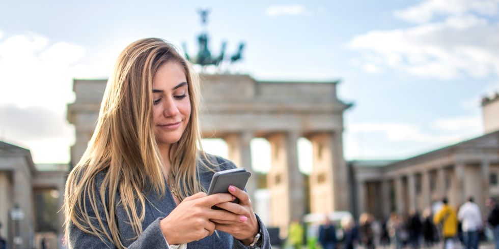 Frau mit Smartphone am Brandenburger Tor