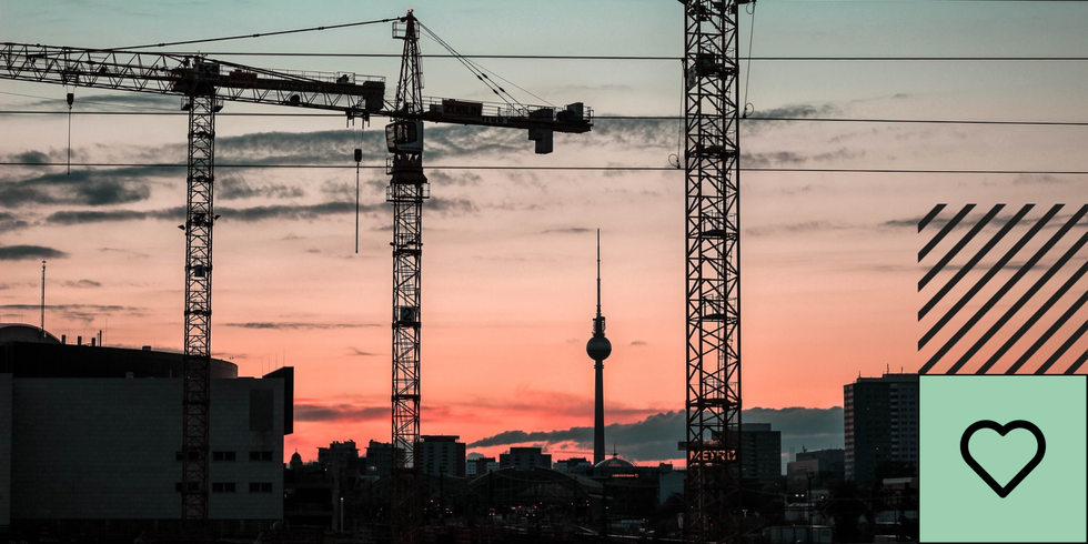 Der Fernsehturm und Kräne auf einer Baustelle in Berlin von der Warschauer Brücke aus gesehen.