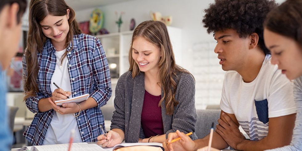 Schülerinnen und Schülern befassen sich in Gruppenarbeit mit einer Aufgabe