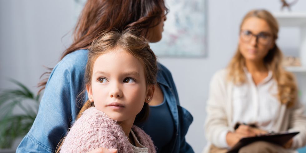 Mutter sitzt mit Kind bei einem Beratungsgespräch