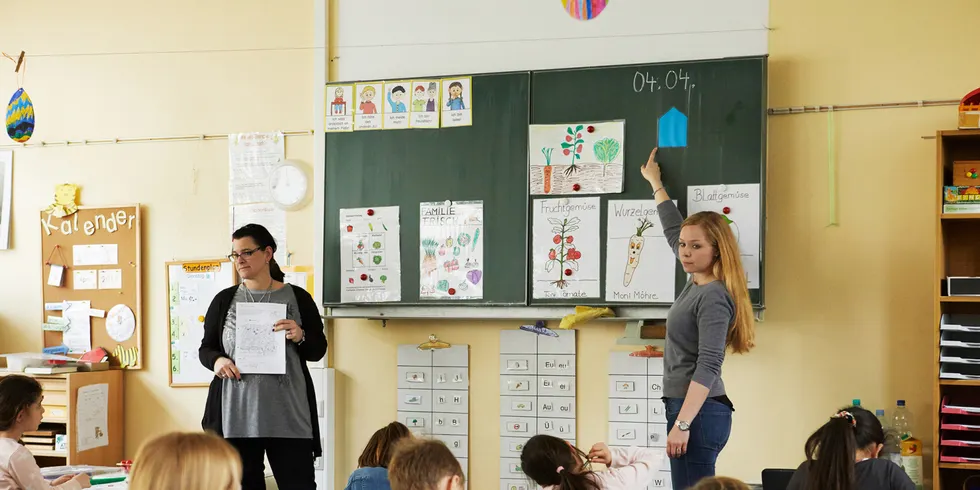 Lehrerin an der Tafel vor Klasse