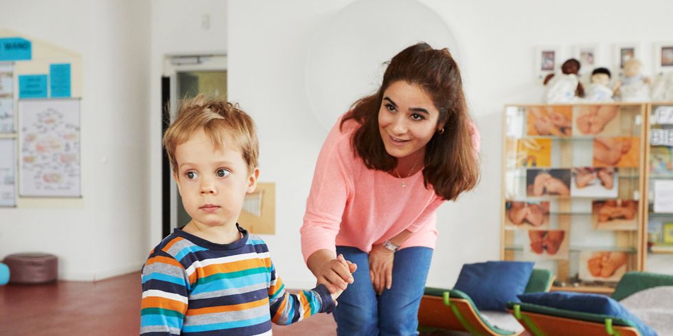 Erzieherin spricht mit Jungen in Kita