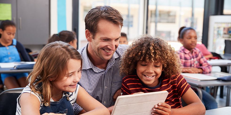 Lehrer mit Schülerin und Schüler und Tablet