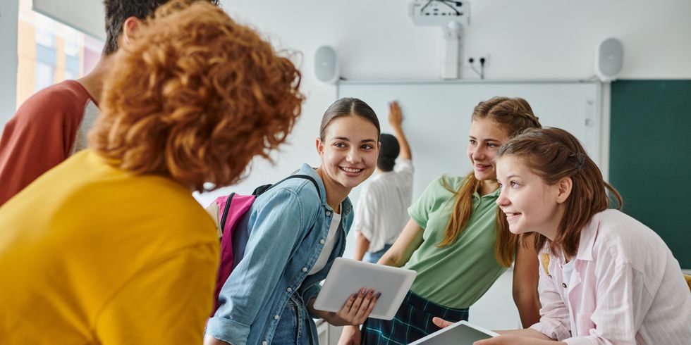 Teenage students engaging and laughing in a vibrant classroom during back-to-school season
