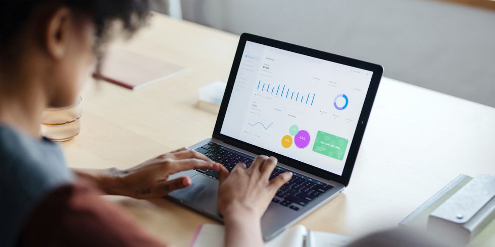 Frau arbeitet an Laptop, auf welchem Statistiken abgebildet sind