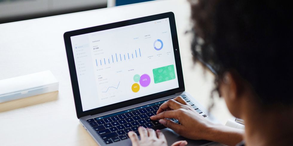 Frau arbeitet an Laptop, auf welchem Statistiken abgebildet sind
