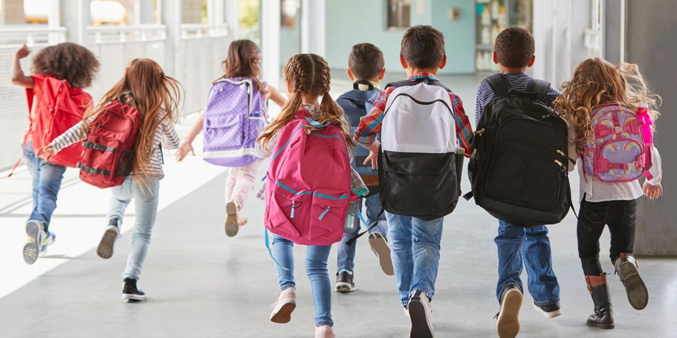 Schüler mit Rucksack rennen zum Eingang