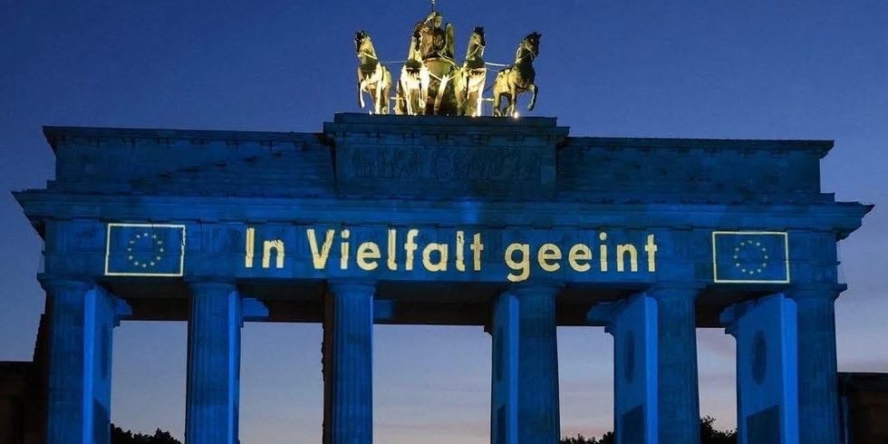 Europäisch beleuchtetes Brandenburger Tor mit Menschen davor