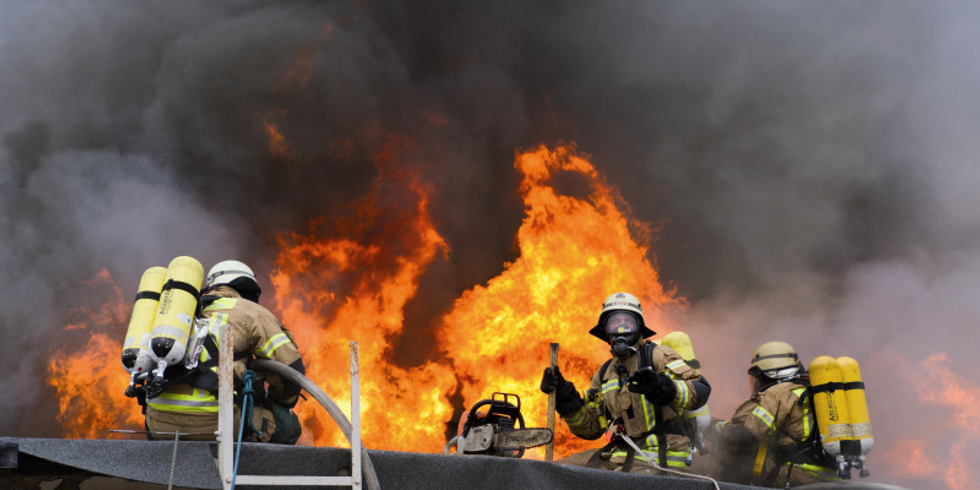 Feuerwehr´leute auf brennendem Dach