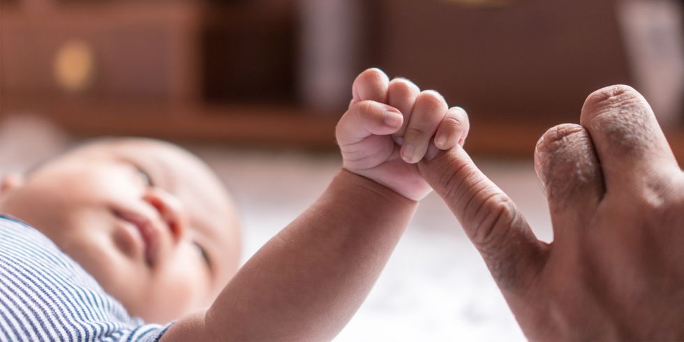 Neugeborenes Baby greift Finger von Erwachsenem