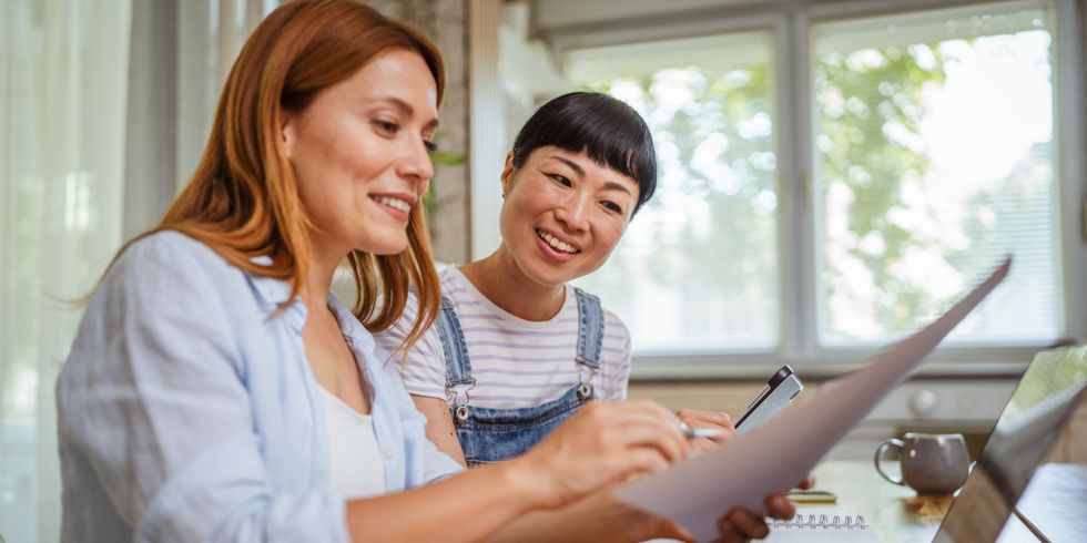 zwei Frauen sitzen an einem Tisch und beraten sich