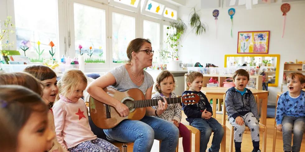 Erzieherin singt mit Kitakindern