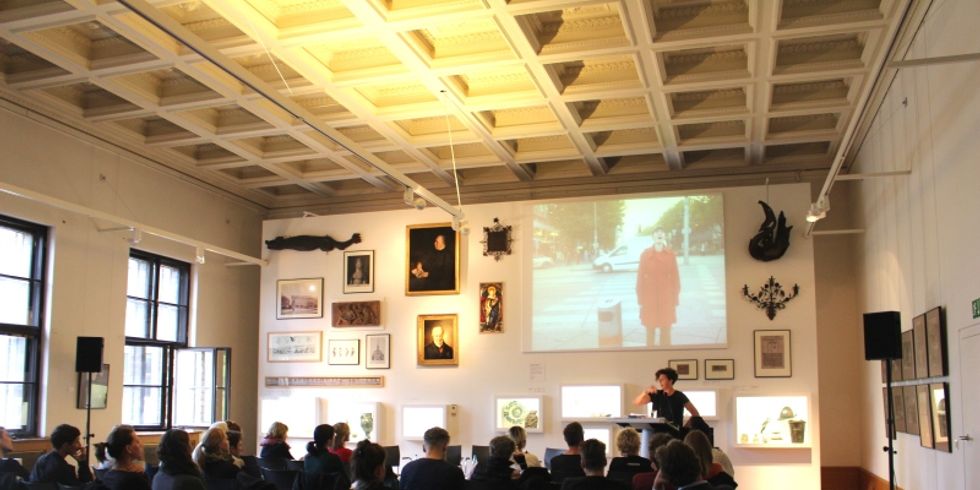 Bärenzwinger Symposium, sitzende Personengruppe vor Leinwand