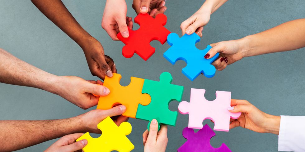 High Angle View Of Medical Team Solving Jigsaw Puzzle