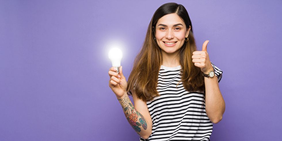 Junge Frau mit Glühlampe in der Hand