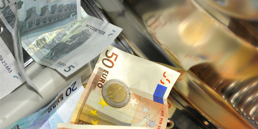 Geldscheine und Münzen in Wäschetrommel