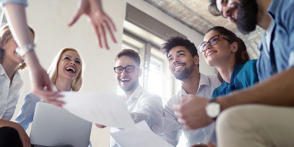 Personen in einer Runde freuen sich über Ihre Zusammenarbeit