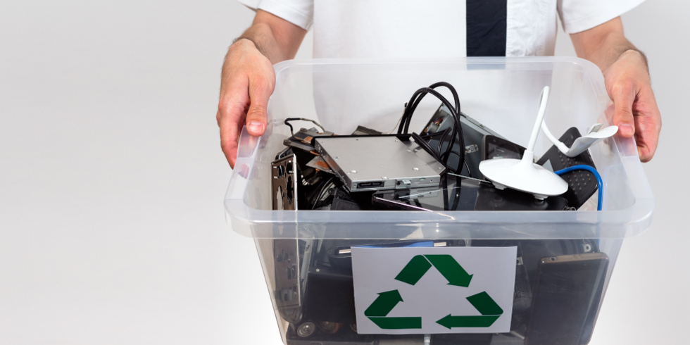 Mann trägt Kiste,befüllt mit Elektronik zum recyceln