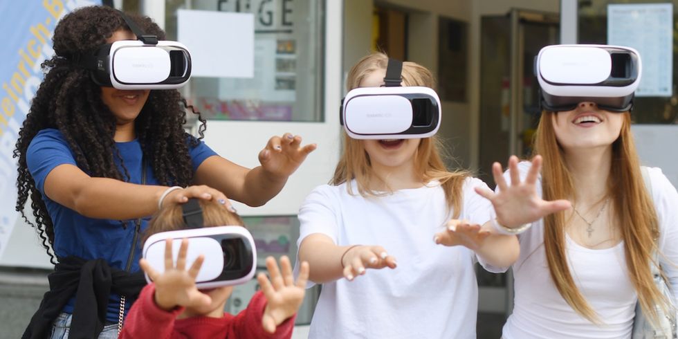 Kinder und Jugendliche spielen mit Virtual-Reality-Brillen