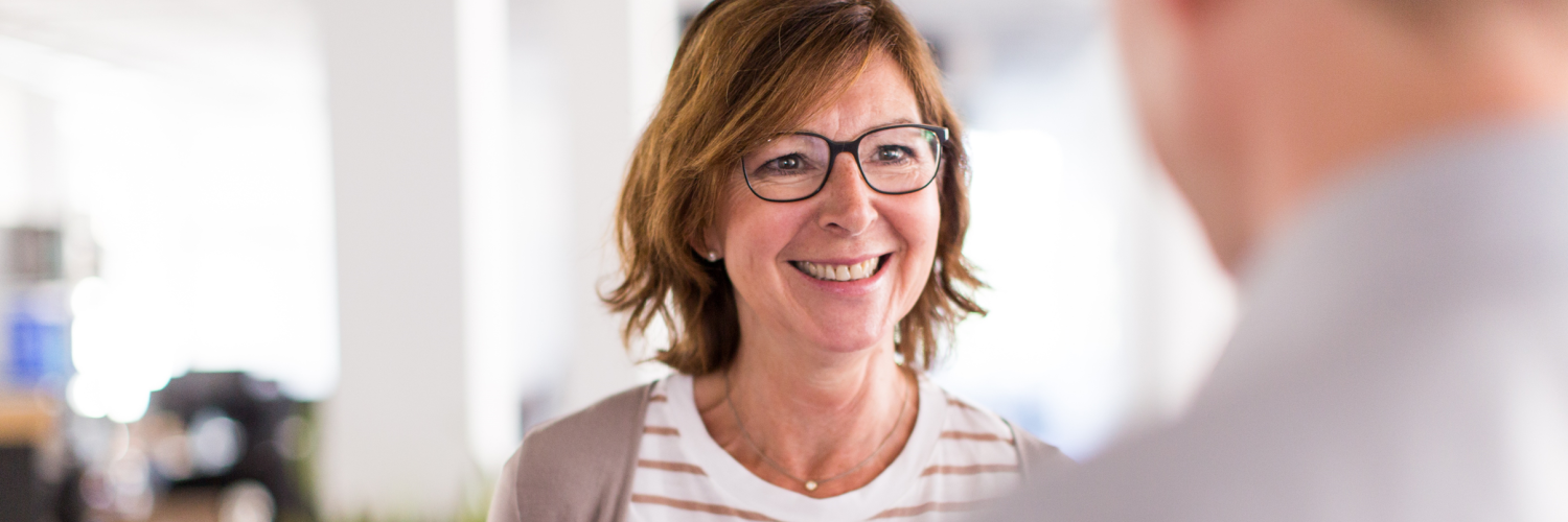 Portrait einer Frau, die mit einer weiteren Person spricht