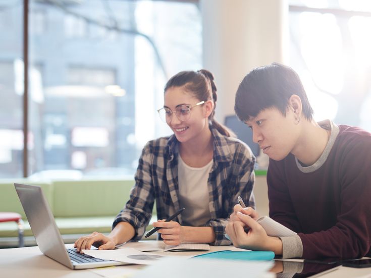 Zwei Studierende arbeitet gemeinsam an einem Laptop