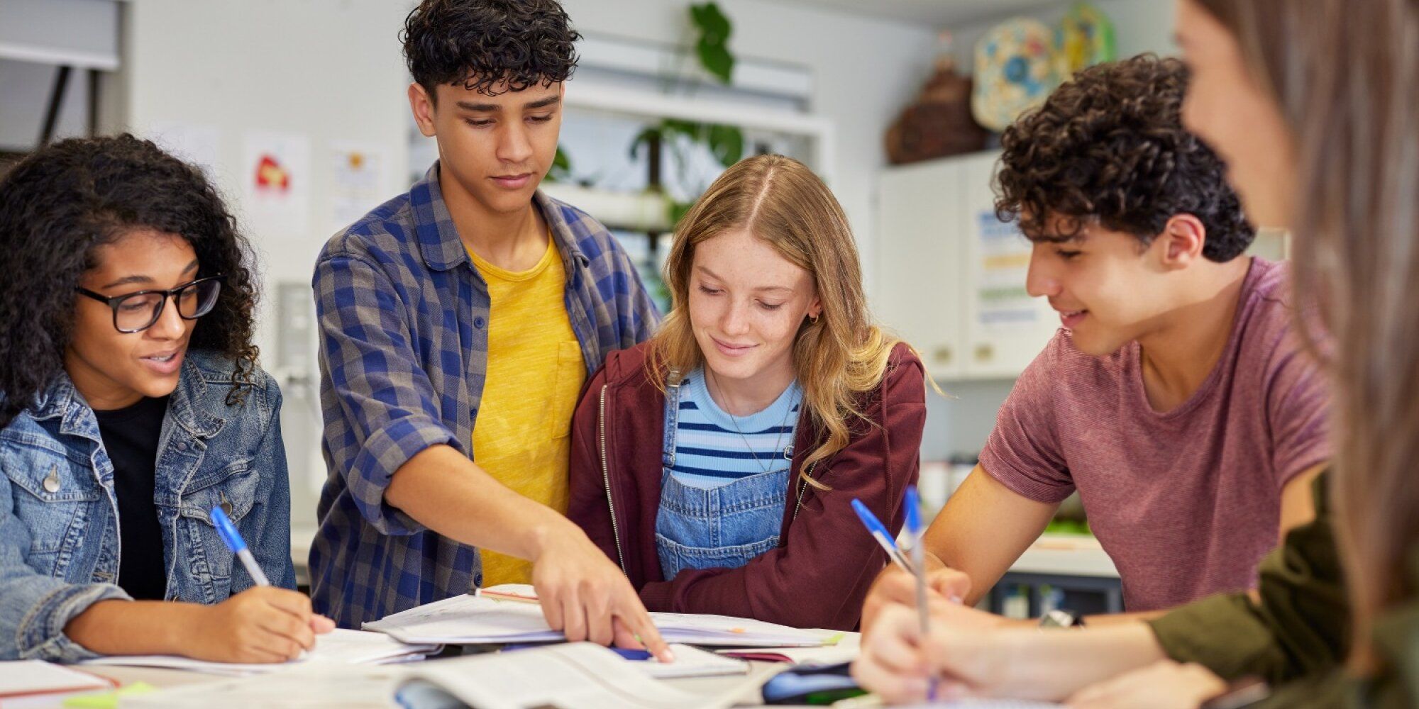 Schülerinnen und Schüler verschiedener ethnischer Herkunft bearbeiten gemeinsam Aufgaben