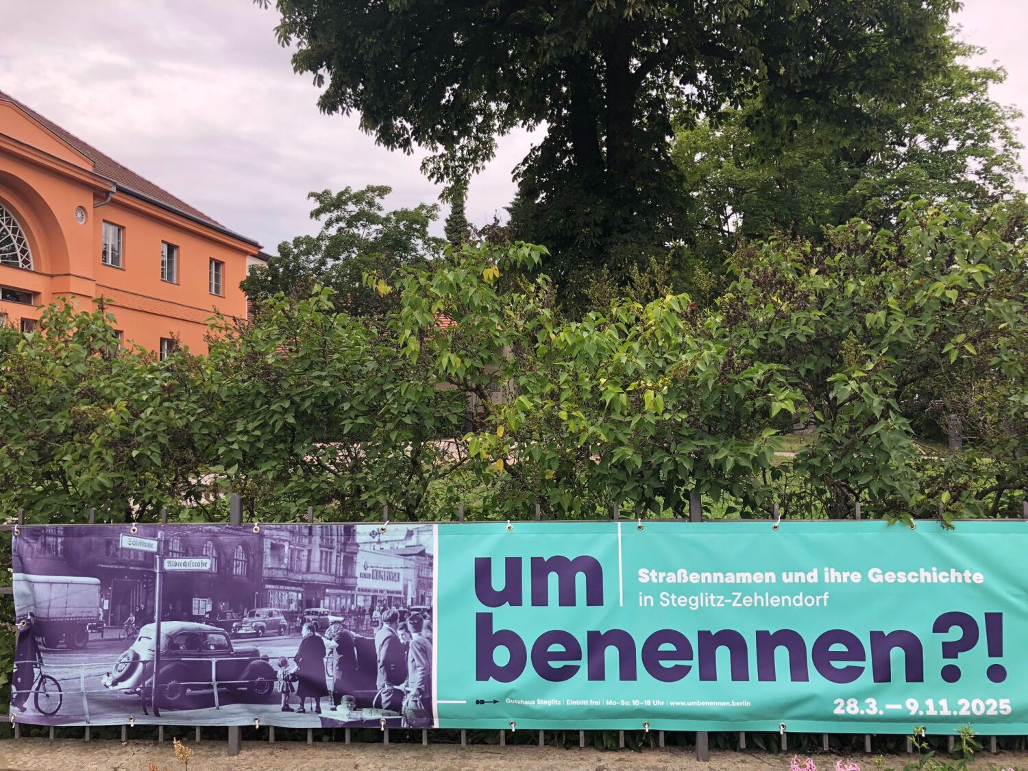 Direkt vor dem Gutshaus Steglitz: Ein Banner lädt zum Ausstellungsbesuch ein