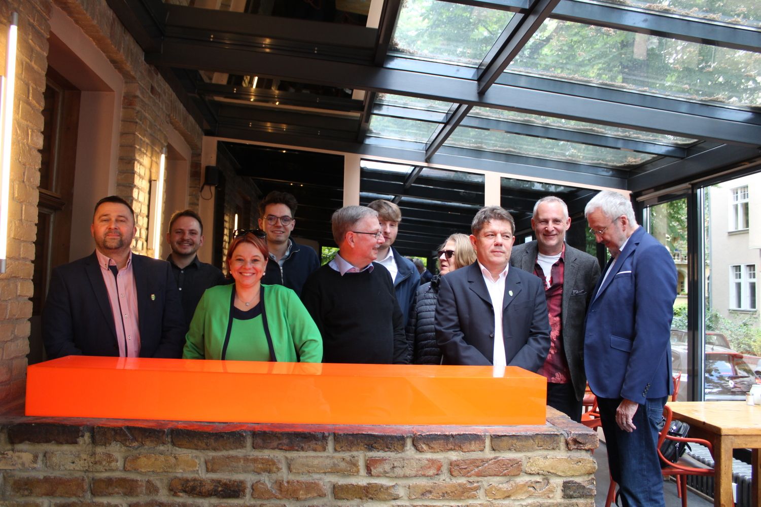 24. Mai 2025: Gemeinsames Gruppenfoto beim Abschlussessen in Steglitz - Andrea Kinisch (stellv. Bezirksbürgermeisterin Zugló, in Grün) mit ihrer Delegation, BVV-Vorsteher René Rögner-Francke (ganz rechts), einige BVV-Verordnete, mehrere Vertreter des Städtepartnerschaftsvereins, der Bezirksbeauftragte für Partnerschaften, Christian Urlaub (2.v.r.)