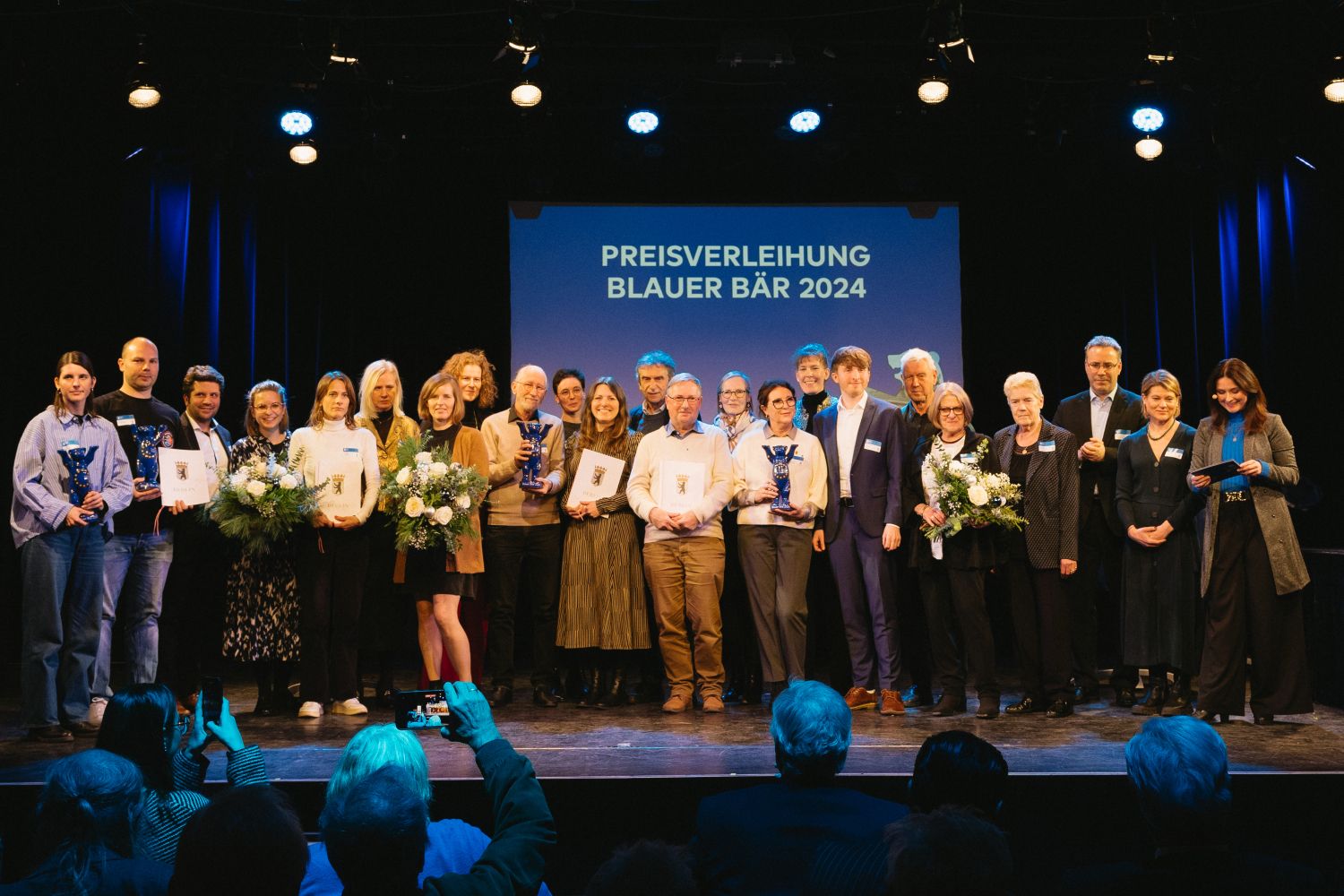 5. Dezember 2024: Verleihung des "Blauen Bären" für europäisches Engagement an den Städtepartnerschaftsverein Steglitz-Zehlendorf e.V. Im Bild zu sehen sind Sebastian Leskien (7.v.r.), Gisela Pflug (mit Blumenstrauß, 5.v.r.), Rolf Breidenbach (11.v.r.), Olga Pischel (mit Bärentrophäe, 9.v.r.), Elke Dietrichs (4.v.r.), Heinz-Joachim Elbe (6.v.r.).