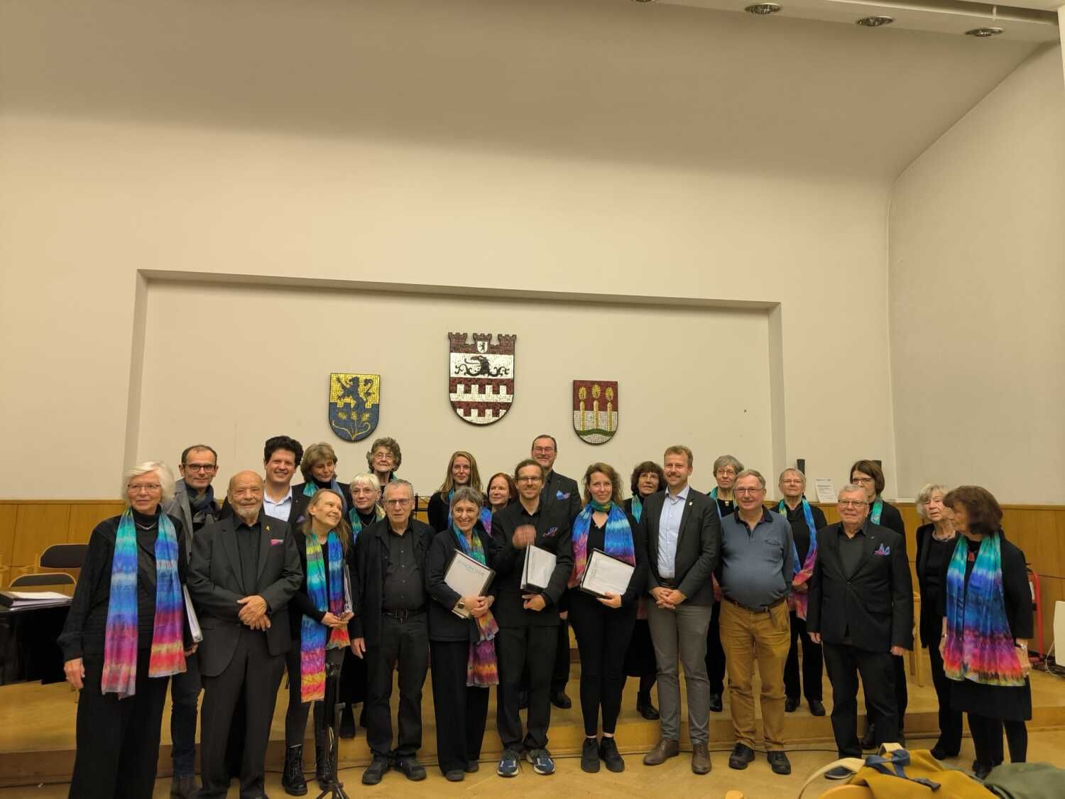 11. November 2025: Gruppenfoto mit Sängern, Sängerinnen und Prominenz: Bezirksstadtrat Patrick Steinhoff (erste Reihe, 4.v.r.), rechts daneben Rolf Breidenbach (stv. Vorsitzender Städtepartnerschaftsverein), Redner Armin Hoffmann (erste Reihe, 2.v.l.), Pedro Elsbach (erste Reihe, 4.v.l.)