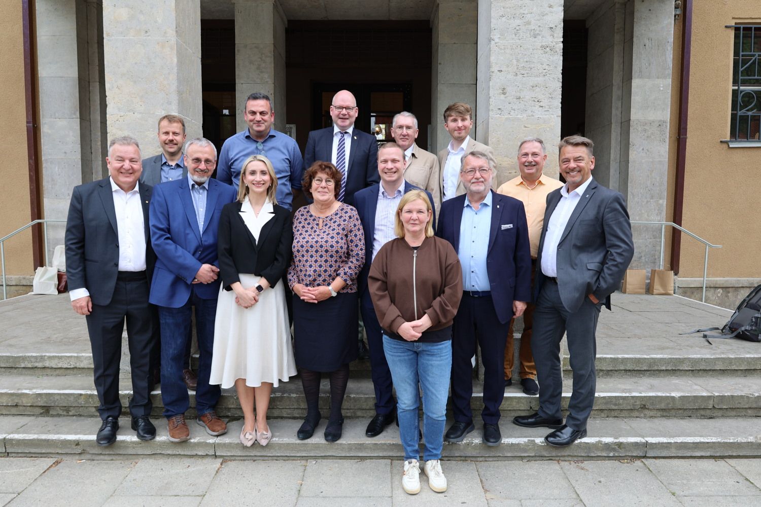 22. Mai 2026: Rund um die beiden Bürgermeister gruppierte Vollversammlung vor den Säulen des Hauptportals des Rathauses Zehlendorf: die schwedische Delegation mit Vertretern aus Bezirksamt, Bezirksverordnetenversammlung und Städtepartnerschaftsverein. Ganz vorne: Bezirksstadträtin Carolina Böhm (Jugend und Gesundheit); Zweite Reihe: 2.v.l. BVV-Vorsteher René Rögner-Francke, rechts daneben Bezirksstadträtin Malgorzata Sijbrandij (Bildung, Kultur und Sport), 2.v.r. Rolf Breidenbach, stv. Vorsitzender des Städtepartnerschaftsvereins; Hintere Reihe: v.l.n.r. Bezirksstadträte Patrick Steinhoff (Stadtentwicklung), Urban Aykal (Ordnung, Umwelt- und Naturschutz, Straßen und Grünflächen) und Tim Richter (Bürgerdienste und Soziales)
