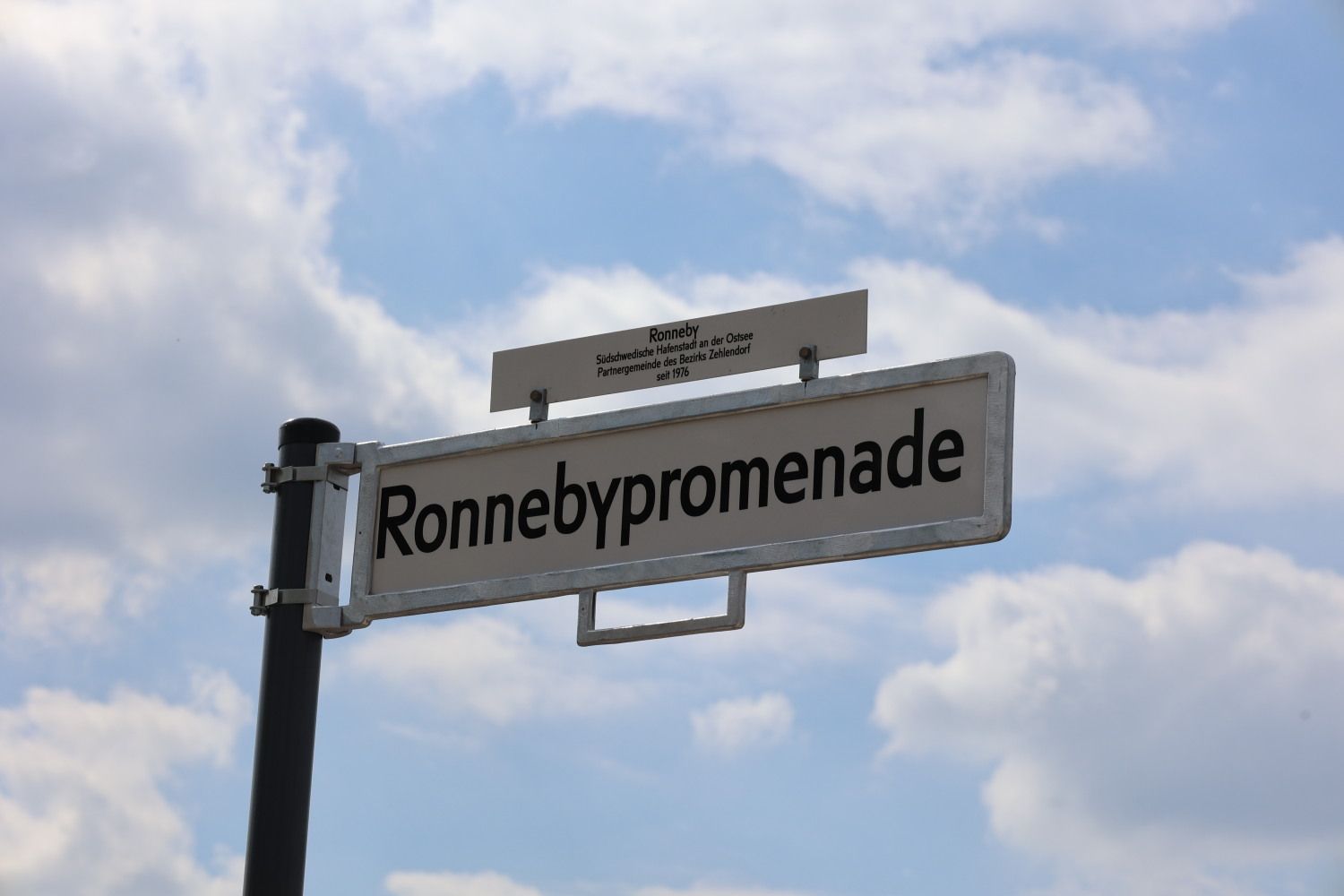 22. Mai 2026: Frisch enthüllt vor frühlingshafter Himmelskulisse: Das Schild der Ronnebypromenade (Wannsee)