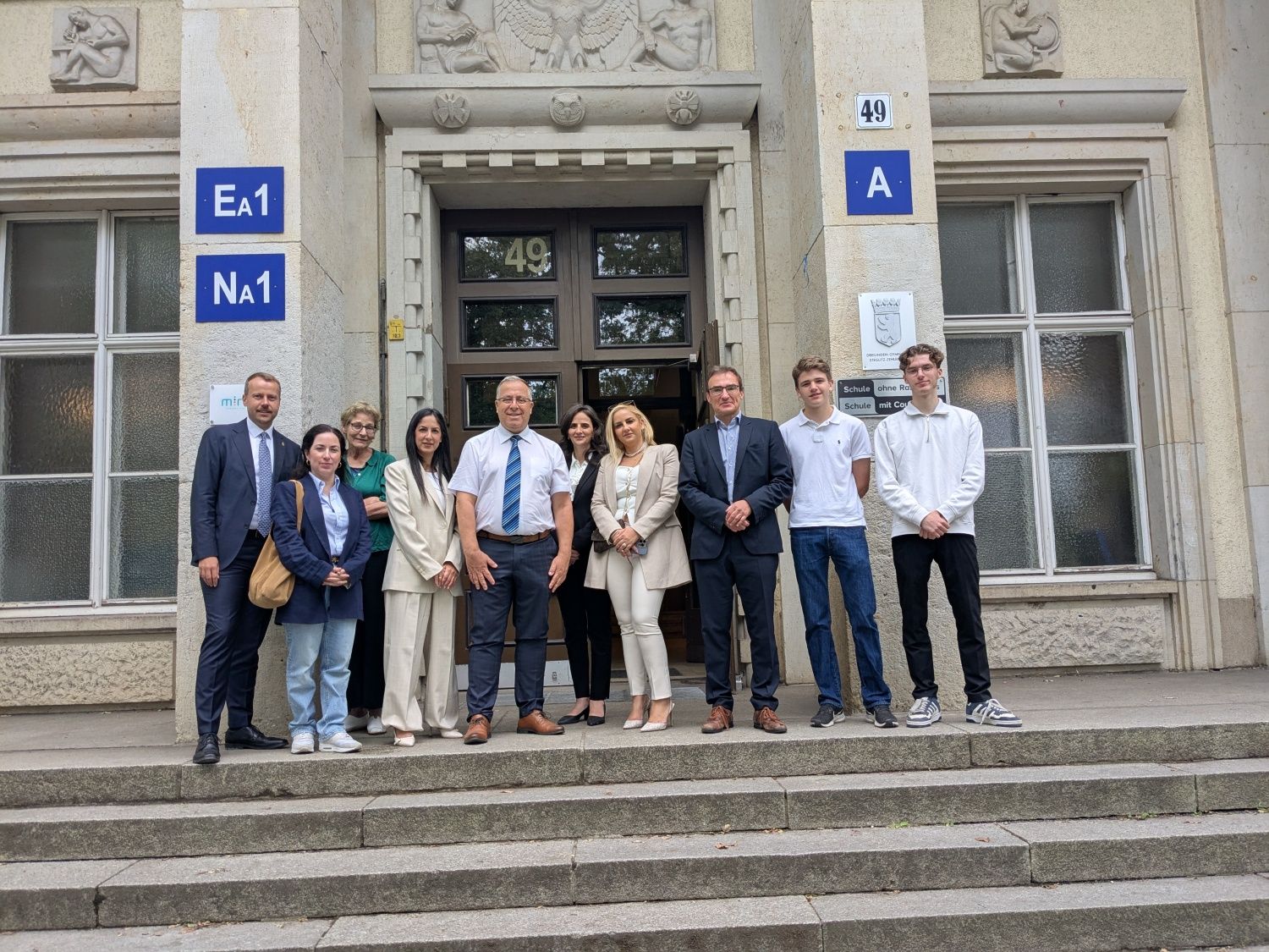 8. Juli 2025: Gruppenbild vor dem Haupteingang des Dreilinden-Gymnasiums: abgebildet u.a. Bürgermeister Eli Dukorksy (Mitte, mit Krawatte), Bezirksstadtrat Patrick Steinhoff (ganz links), Schulleiter Jens Stiller (3.v.r.)